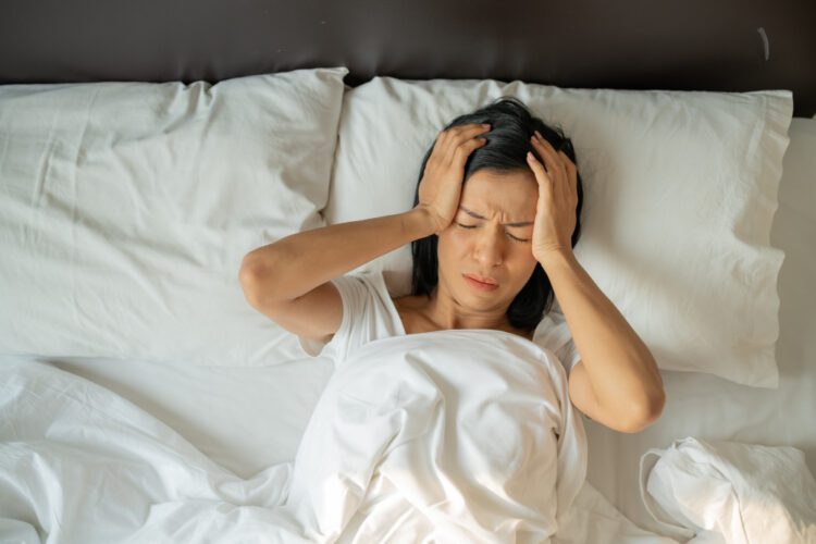 jovem mulher com crise de insonia na cama